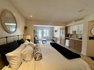 a bedroom with a large white bed and a kitchen at Newly Renovated Ski-In Ski-Out 1-Bedroom Condo with Pool, Gym, Sauna by Horseshoe Valley in Edgar +53 photos