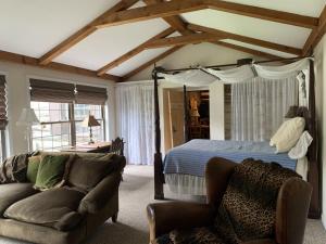 una camera con letto a baldacchino e divano di Alpine Lakeside Manor a Terra Alta