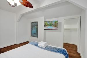 a white bedroom with a bed and a window at Tropical Oasis 2BR w Pool in Fort Lauderdale