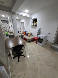 a living room with a table and a couch at Apartament Rinia in Pogradec in Pogradec