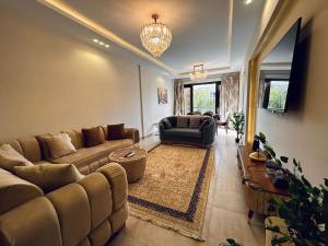 a living room with a couch and a chair at Serene City Stay next to the AUC, New Cairo in Cairo