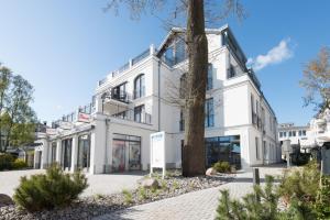 ビンツにあるFerienwohnung Treibholz in der Villa Martha Binzの前に木がある白い建物