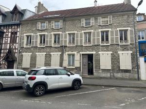 a white car parked in front of a brick building at Bonheur en Seine, Piscine, Vue Seine in Poissy