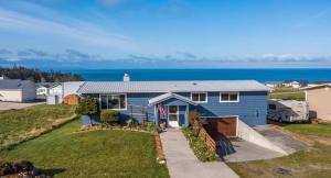 a blue house with the ocean in the background at Perch - Sierra Retreat 47 in Coupeville