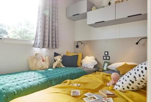 a childs bedroom with two beds and a window at Domaine Résidentiel de Plein Air Monplaisir in Saint-Trojan-les-Bains