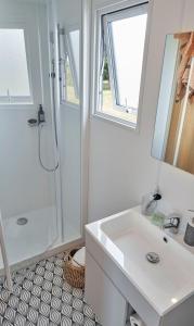 a white bathroom with a sink and a shower at Domaine Résidentiel de Plein Air Monplaisir in Saint-Trojan-les-Bains +34 photos