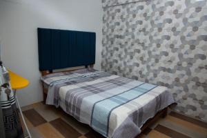a small bed in a room with a wall at Apartamento La Merced in La Merced