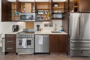 a kitchen with stainless steel appliances and wooden cabinets at Perch - Centro house F in Seattle
