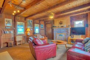 a living room with a red couch and a fireplace at KD1511- Sea Chanty in Kill Devil Hills