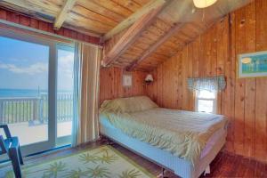 a bedroom with a bed in a room with a window at KD1511- Sea Chanty in Kill Devil Hills