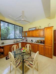 a kitchen with a glass table and chairs in it at Tropical Oasis in Teldeniya +20 photos