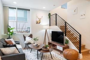 a living room with a tv and a staircase at Perch - The Ashworth 69 in Seattle