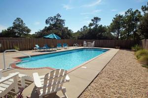 a swimming pool with two chairs and adozen at WH1020- Crab Quarters in Corolla