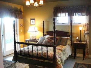 a bedroom with a canopy bed in a room with windows at Y1485- Sunnybank in Corolla +20 photos