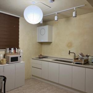 スウォンにあるStay Ducksanのキッチン(白いキャビネット、電子レンジ付)
