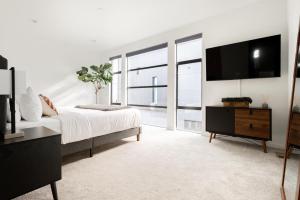 a bedroom with a bed and a flat screen tv at Urban Oasis - Rooftop Delight - Peloton - RiNo in Denver