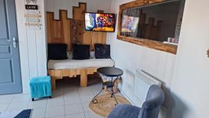 a small room with a bench and a tv at Gîte l'hippocampe in Jarjayes