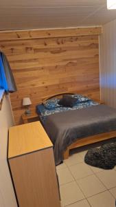 a bedroom with a bed with a wooden wall at Gîte l'hippocampe in Jarjayes