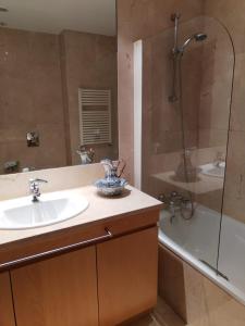 a bathroom with a sink and a shower at Apartamento Centro Guimarães com Vista Panorâmica in Creixomil