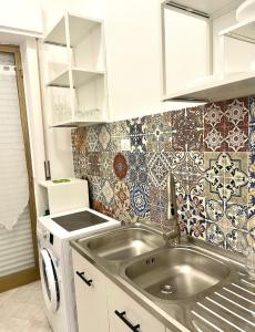 una piccola cucina con lavandino e piastrelle sul muro di Casa Mondello Sea Life a Palermo