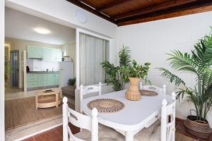 Una sala de estar con una mesa y sillas blancas. en Tranquil Coastal Escape, Porís de Abona, en Porís de Abona