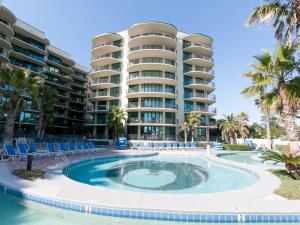 una piscina con sillas frente a un edificio en Phoenix On The Bay 1225 by Liquid Life, en Orange Beach