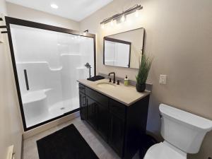 une salle de bain avec un lavabo, des toilettes et un miroir dans l'établissement Boji Cottage off West Lake Okoboji, à Okoboji 31 autres photos