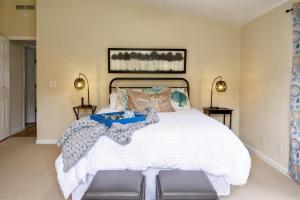 a bedroom with a large white bed with two lamps at Coracao do Mar in Fort Bragg