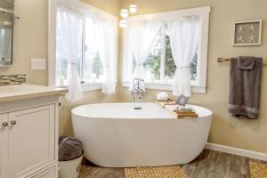 a large white tub in a bathroom with windows at Coracao do Mar in Fort Bragg +21 photos