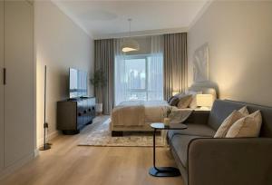 a living room with a couch and a bed at Signature Studio JLT in Dubai
