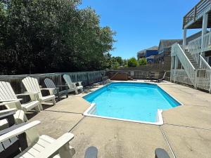 a swimming pool with lounge chairs at KH4508- Surf Par-Tee in Kitty Hawk