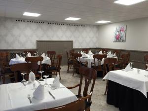 a dining room with tables and chairs with white tablecloths at Hotel Restaurante Derby in Carballino