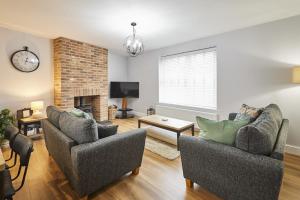 a living room with two chairs and a fireplace at Host & Stay - Cedar Cottage in Belford