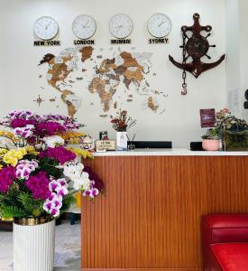 a counter with clocks on the wall and flowers at Kim Hotel Vincom Tây Ninh in Tây Ninh
