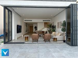 a living room with sliding glass doors and a couch at 3BR Modern Seashore Private Villa with swimming Pool in Fujairah