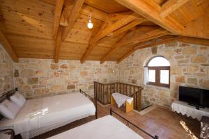 um quarto com uma cama e uma televisão num edifício em Fioro Stone House em Tsilivi
