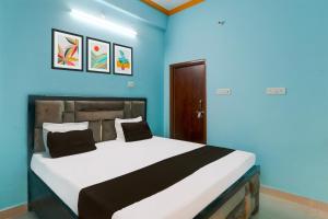 a bedroom with a large bed with blue walls at Hotel O SK in Sītāpur