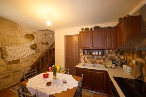 uma cozinha com uma mesa e uma cozinha com uma escada em Fioro Stone House em Tsilivi