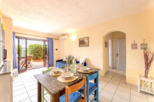 eine Küche und ein Wohnzimmer mit Tisch und Stühlen in der Unterkunft Golfo Aranci Apartments With Ac in Marinella + 21 Fotos