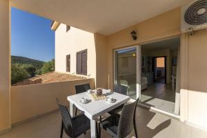 ein Esszimmer mit Tisch und Stühlen auf einem Balkon in der Unterkunft Golfo Aranci Apartments With Ac in Marinella