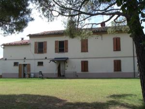 Biały dom z brązowymi oknami i zielonym polem w obiekcie Agriturismo Ca'de'Gatti w mieście Faenza