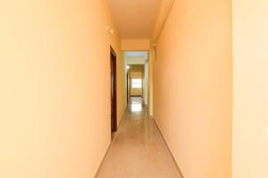 un couloir vide avec des murs orange et un long couloir dans l'établissement Townhouse VSK group of hotels, à Hyderabad