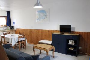 a living room with a blue couch and a table at Domaine Des Piéris - Gîtes et Lodges in Grandcamp-Maisy