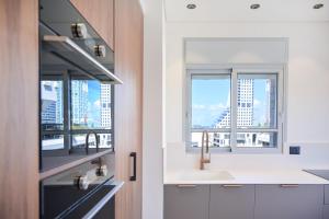a kitchen with a sink and two windows at Allenby 36 Bauhaus Residence 5 Stars in Tel Aviv +126 photos