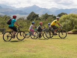 a group of people riding bikes in a field at Malealea Lodge in Malealea