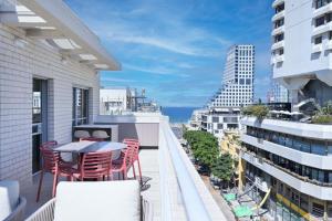 a balcony with chairs and a table on a building at Allenby 36 Bauhaus Residence 5 Stars in Tel Aviv