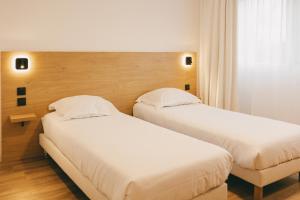 two beds in a hotel room with white sheets at Miranove in Montpellier +64 photos