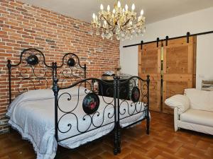 a bedroom with a black bed and a brick wall at VILLA LAGO GROUND FLOOR- Pet friendly stay-private garden-parking-Lake view - Bike friendly holiday house in Colico