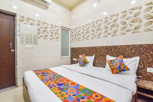 a bedroom with a large bed with colorful pillows at FabHotel Maa Gayatri Sadan - Nr Pram Mandir Shree Banke Bihari Temple in Vrindāvan