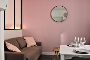 a living room with a couch and a mirror at Le Flamingo - Wifi - 400m centre Pontivy in Pontivy